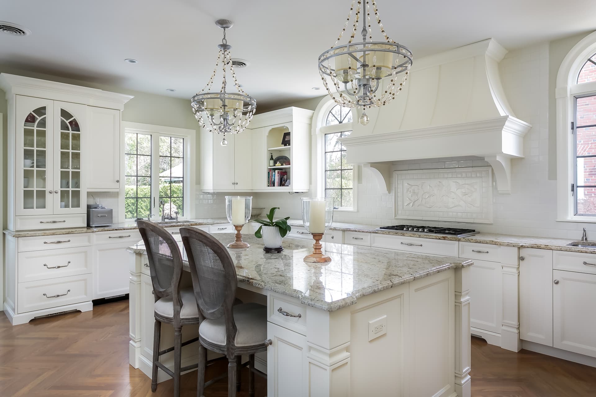 Classic white chef's kitchen with a marble island and crystal chandeliers in a Haddonfield, NJ home