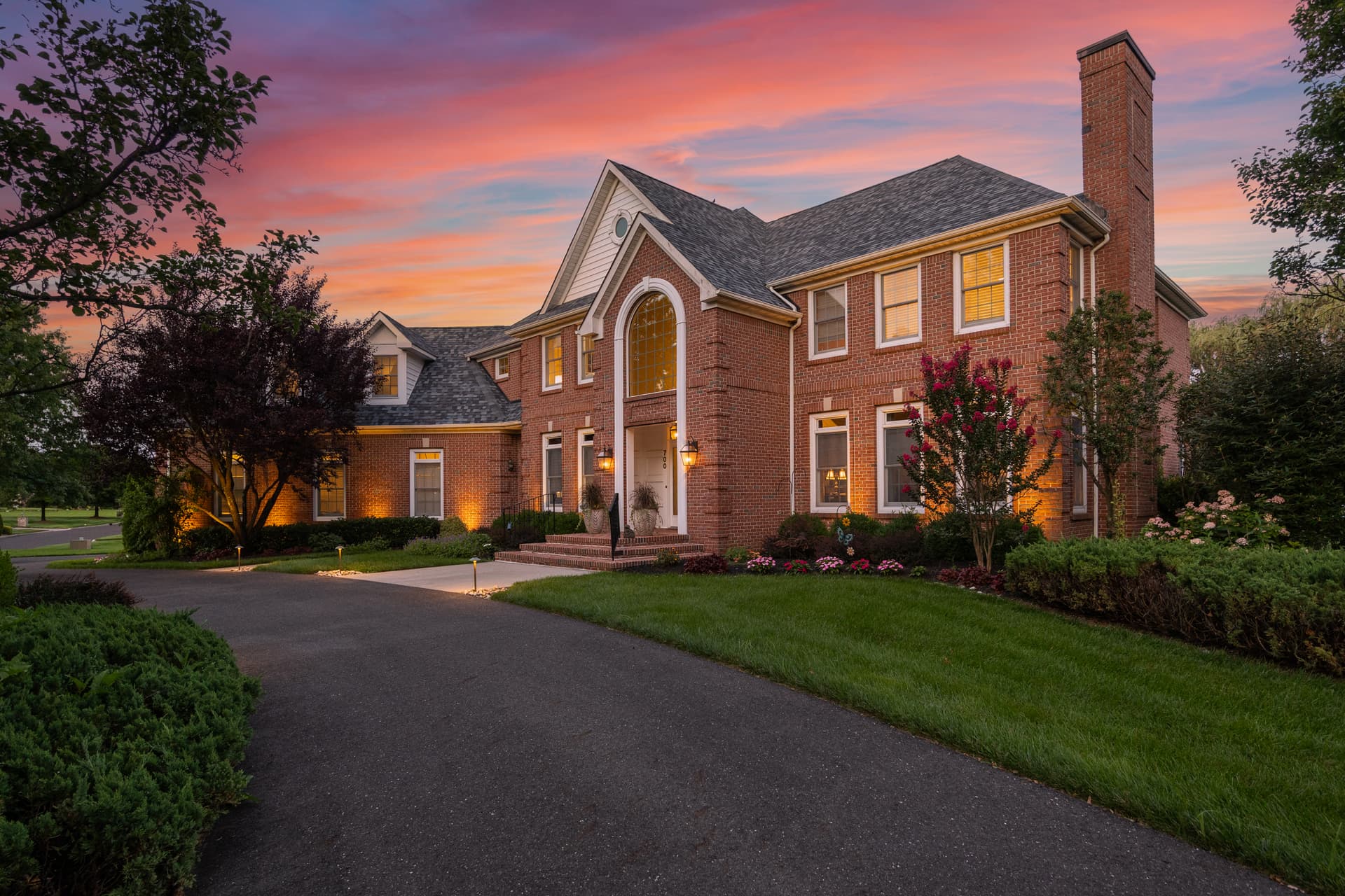 Twilight photography of a brick colonial under a fiery dusk sky, South Jersey