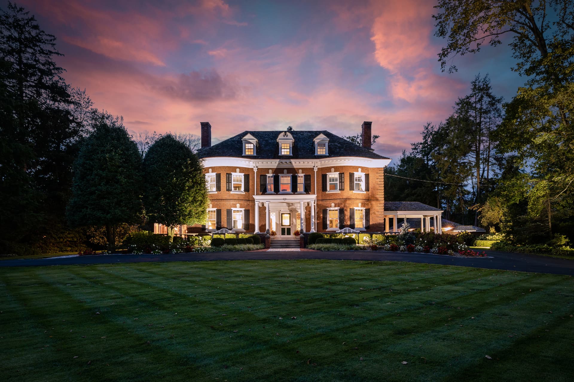 Twilight photography of a Georgian brick estate glowing at dusk, South Jersey
